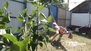 Blonde masturbates on a hammock